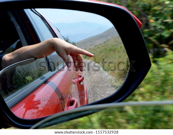 hand out window of red\
car