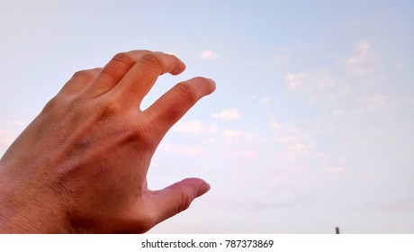 Hand over a cloudy sky