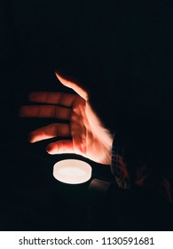 A Hand Over A Light Source In The Dark