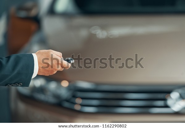 Hand of\
owner using electronic car key to open\
door