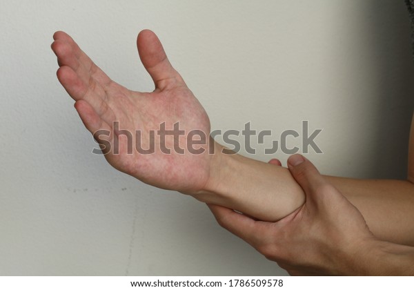 Hand pain. Closeup man holds wrist and hand. hand\
injury, feeling pain. Health care and medical concept. Joint\
arthritis and treatment. Hand Inflammation or arthritis and\
repetitive motion injury