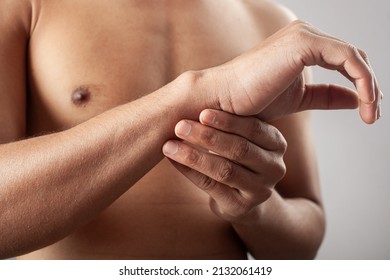 Hand Pain, Wrist Injury. Shirtless Young Man Holding Wrist Soreness Zone.