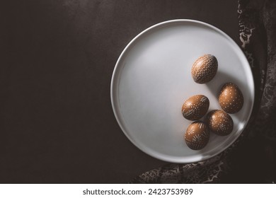 Hand painted easter eggs on white ceramic plate over black rustic coun ter top. Directly above table top shot. - Powered by Shutterstock