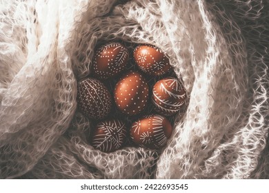 Hand painted easter eggs wrapped with knitted wool blanket. Directly above table top view