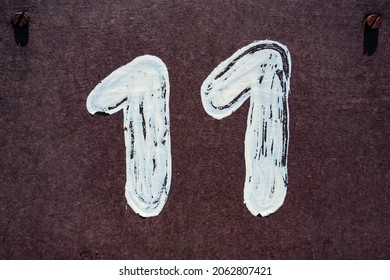 Hand painted house number eleven (11) on concrete plywood
