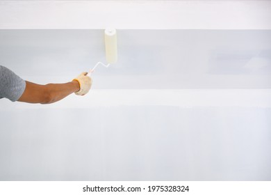 Hand Painted Portrait Painting The Ceiling Inside The House And Building. Workers Use A White Primer Paint Roller On The Construction Site.