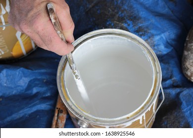 Hand Of Painter Holding Stirrer, Stirring White Paint