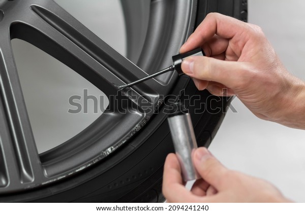 The hand painting the car wheel with a\
brush. Close up. Isolated on a white\
background.