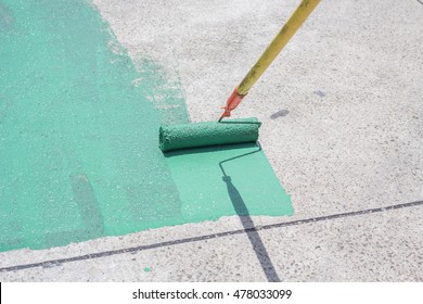 Hand Painting A Green Floor With A Paint Roller For Waterproofing