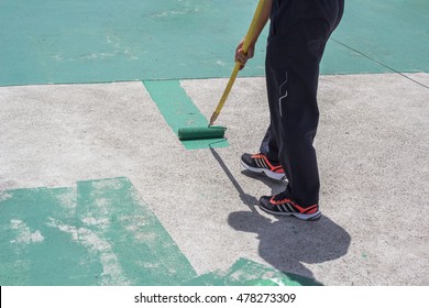 Hand Painting A Green Floor With A Paint Roller For Waterproofing