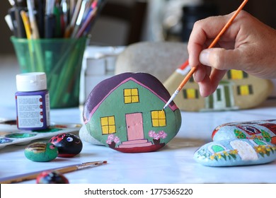 hand painting stone as home with small brush, leisure activity