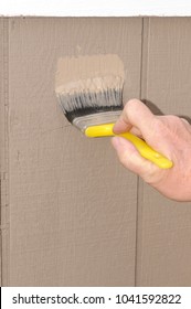 Hand Painting T111 Siding On A House, Ensuring To Get Paint In The Grooves