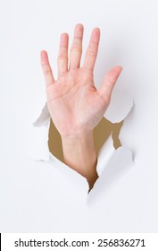 Hand Palm Breaking Through Paper Wall