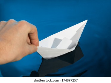 Hand And Paper Boat. Launching A Ship.