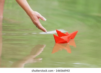 Hand And Paper Boat In River