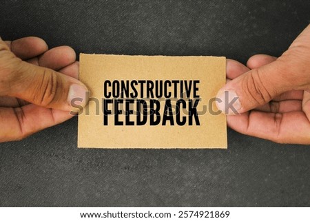 hand and paper with the word constructive feedback. the concept of consumer or customer response. a response to someone's activity aimed at helping them become more effective