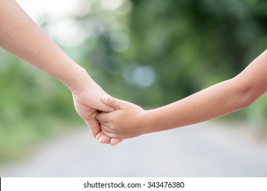 hand of parent and child on the background blurred nature.Mother holding hands baby