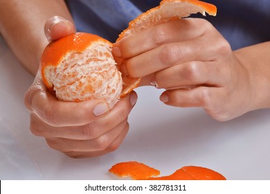 Hand peeling tangerine fruit. - Powered by Shutterstock