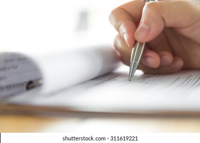 Hand with pen over application form - Shutterstock ID 311619221
