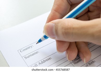 hand with pen over application form, man hands writing on paper