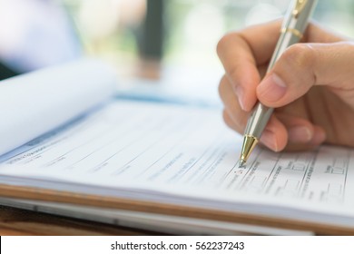 Hand with pen over application form - Shutterstock ID 562237243
