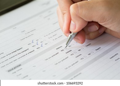 Hand with pen over blank check boxes in application form - Shutterstock ID 106693292