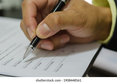 Hand with pen to sign the document