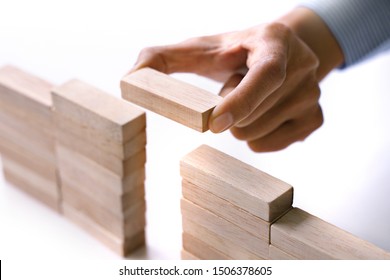 Hand Of People Building Up The Wooden Brick Block Bridge Wall, Business Risk And Strategy Concept.