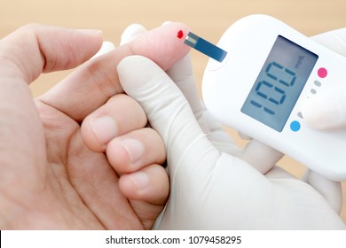 Hand Of People Check Diabetes And High Blood Glucose Monitor With Digital Pressure Gauge. Healthcare And Medical Concept