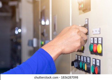 Hand of people key switch select mode in electrical control panel contains switch buttons for operating industrial machine and factory equipment in industry
