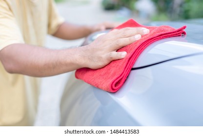 Hand Of People Using Red Cloth To Cleaning Body Of SUV Car. Cleaning Or Washing Car Concept