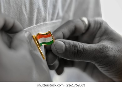 Hand of person holding badge of Indian flag, tricolor with Ashok chakra. Freedom, independence, patriotism, nation, love, respect, salute, republic, white, saffron, green, patriotism, unfurl, hoisting - Powered by Shutterstock