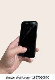 hand of a person holding a black Broken screen smartphone with copy space. Isolated on white background with clipping path. It can be used to promote the phone repair shop.