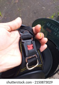 The Hand Of A Person Holding A Helmet Strap