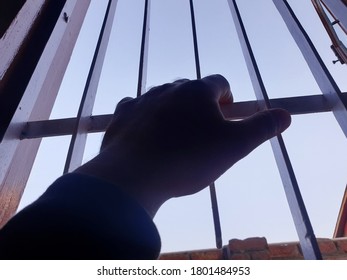 Hand Of A Person On Window Iron Roads. Sign Of Lockdown During Coronavirus Through Out The World. World Health Organisation Says To Be In Home. 