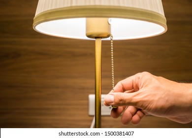 Hand of person is turning on or turning off the bedroom 's head lamp which is beautiful luxury-modern designed. Close up and selective focus photo. - Shutterstock ID 1500381407