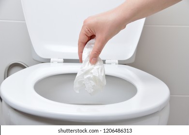 Hand Of A Person Who Drop Tissue Paper In The Toilet Bowl