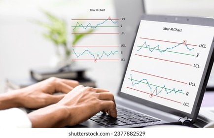 Hand of person work with laptop and monitoring Xbar-R chart graph and analysis problem red some point at workplace in office