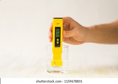 A Hand With A PH Measuring Instrument. Bad Indicators Of Drinking Water. Rigid Water. Tap Drinking Water Quality Control Showing A High Level Of TDS Total Dissolved Solids