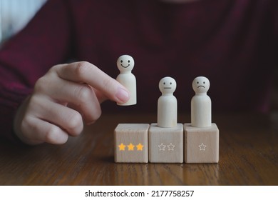 Hand Pick Happy Face Wooden Figure. Customer Service Rating Experience And Feedback Emotion And Satisfaction Survey. Human Resources Management Choosing Positive Attitude To Team.