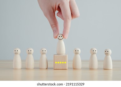 Hand Pick Happy Face Wooden Figure. Customer Service Rating Experience And Feedback Emotion And Satisfaction Survey. Human Resources Management Choosing Positive Attitude To Team.