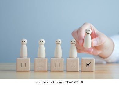 Hand Pick Happy Face Wooden Figure. Customer Service Rating Experience And Feedback Emotion And Satisfaction Survey. Human Resources Management Choosing Positive Attitude To Team Leader.