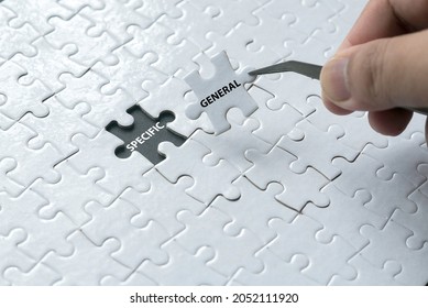 A hand pick a piece of jigsaw puzzle written with General and an empty space of jigsaw puzzle written with Specific. - Shutterstock ID 2052111920