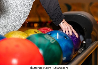 Hand Picking Up Bowling Ball At Bowling Alley.