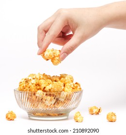 Hand Picking Caramel Popcorn Filled In Crystal Clear Bowl On White Background