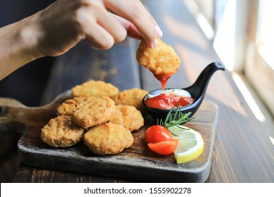 Hand Picking Chicken Nugget To Sauce For Eating  