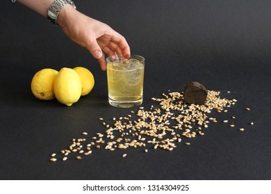 Hand Picking Up Cocktail Drink From Black Table. Lemony Cocktails In Time To Kick Off Summer.