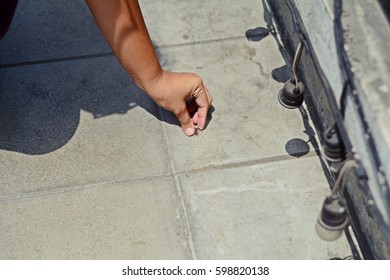Hand Picking Up A Coin On Street
