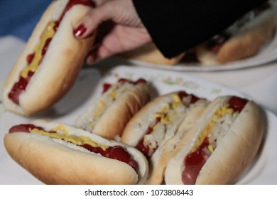 Hand Picking Up A Hot Dog