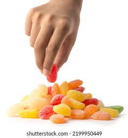 Hand Picking Up Jujube, From A Pile Of Colorful Gummy Type Of Candy Confectionery Isolated On White Background, Close-up With Soft-focus